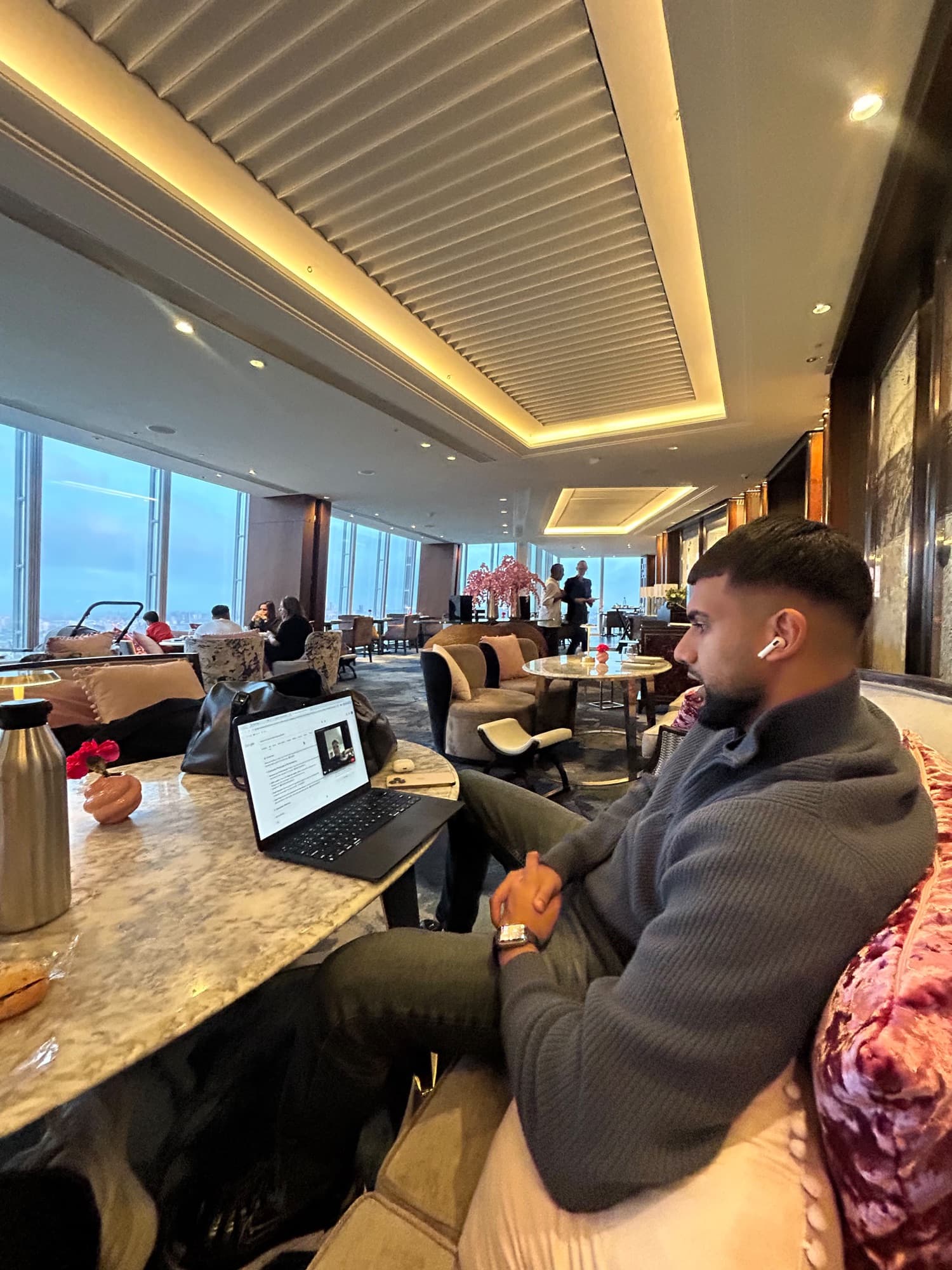 Niral listening to a client on a video call from a hotel lounge